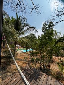 a hammock on a deck next to a swimming pool at Centro Sati Bungalow in Cuatunalco