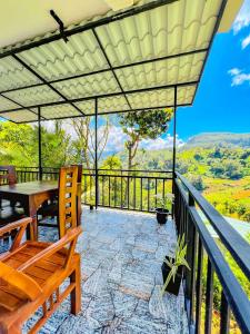 a patio with a table and chairs on a balcony at Bees Honey Cottage Ella in Ella