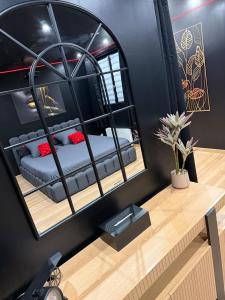a mirror on a desk with a bed in a room at La nuit nocturne in Bolbec