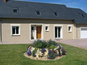 a house with a landscaping in front of it at La brèche fleurie in Cricquebœuf