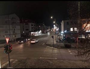 a city street at night with cars on the road at Apartment in Pale in Pale