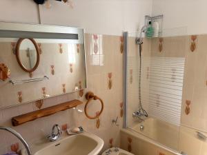 a bathroom with a sink and a tub and a mirror at Le petit gîte in Saint-Étienne-le-Laus