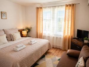 a bedroom with a bed with two towels on it at Orient Apartmanház in Eger