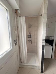 a shower with a shower curtain in a bathroom at Studio cosy & Lumineux parking privé in La Roche-sur-Yon