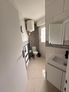 a white bathroom with a toilet and a sink at Studio cosy & Lumineux parking privé in La Roche-sur-Yon
