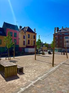 a park with a bench and some buildings at Expérience Balinaise à Amiens in Amiens