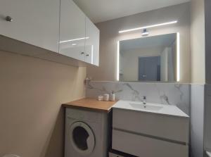 a bathroom with a washing machine and a sink at Appartement à Anglet in Anglet +10 photos