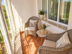 two chairs and a table on a porch with windows at Orient Apartmanház in Eger