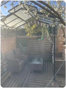 a pergola with two chairs and a table on a deck at Maison avec jacuzzi in Vierzon