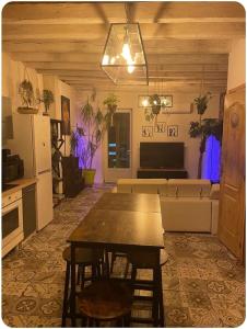 a living room with a table and a couch at Maison avec jacuzzi in Vierzon