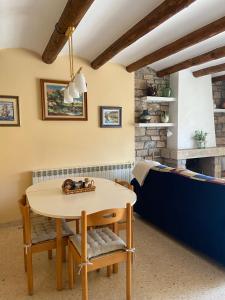 a dining room with a table and a couch at Cal Pelat Guimerà in Guimerá