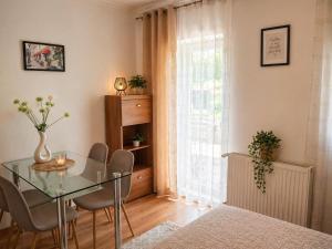 a dining room with a glass table and chairs at Orient Apartmanház in Eger