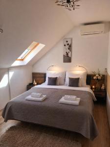 a bedroom with a bed with two towels on it at Orient Apartmanház in Eger +12 photos
