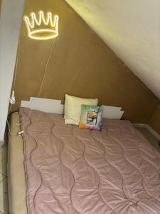 a bed in a room with a crown on the wall at Second&Home in Przeźmierowo
