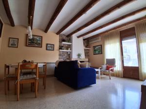 a living room with a blue couch and a table at Cal Pelat Guimerà in Guimerá