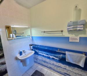 ein Badezimmer mit Waschbecken und einem Wellenmotiv an der Wand in der Unterkunft Apartment Mahlke in Stedar