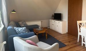 a living room with a couch and a tv at Kajüthus Apartment 1 in Fehmarn