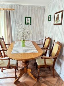 a dining room table with a vase of flowers on it at Chata Baśka in Baligród