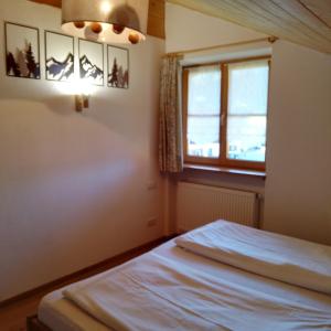 a bedroom with a bed and a window at Haus Rosamirl Ferienwohnung in Wallgau