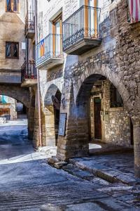an old stone building with an archway on a street at Cal Pelat Guimerà in Guimerá