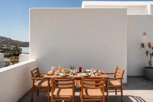 a dining room with a table and chairs on a balcony at Arotron Santorini in Pyrgos