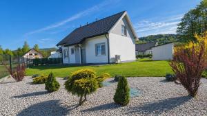 a house with a yard with trees and bushes at Domek Relaks pod Śnieżką in Miłków +8 photos