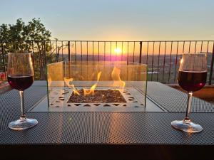 two glasses of wine sitting on a table with a fireplace at Casa degli Angeli in Fermo