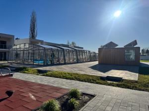a building with a glass greenhouse in front of it at Pino SeaView I in Gdańsk +8 photos