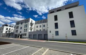 two white buildings on the side of a street at Pod Hajom 101 in Liptovský Mikuláš
