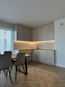 a kitchen with a table and chairs in a room at Pino SeaView I in Gdańsk