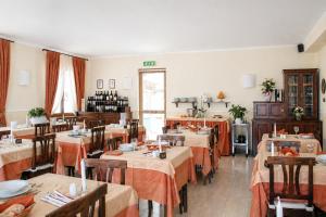 a restaurant with tables with orange tablecloths at Hotel Primula in Alassio