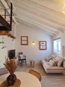 a living room with a couch and a table at Alba Odeceixe - casa aurea in Odeceixe