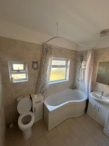 a bathroom with a tub and a toilet and a sink at Rehoboth place in Nottingham +19 photos