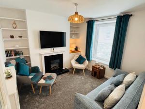 a living room with a blue couch and a fireplace at Cockle Cottage in The Mumbles