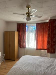 a bedroom with a bed and two windows with red curtains at Rehoboth place in Nottingham