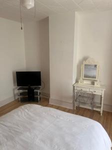 a bedroom with a bed and a desk with a television at Rehoboth place in Nottingham