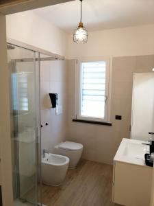 a bathroom with a toilet and a sink and a window at Sea and Airport View in Fiumicino