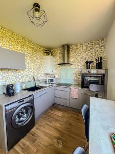 a kitchen with a washing machine and a sink at BayView in Saint-Brieuc