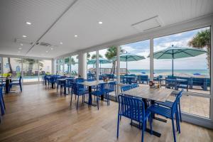 a restaurant with blue chairs and tables and windows at Two Bedroom Two Queen and One King, Sleeps 6 in Pawleys Island