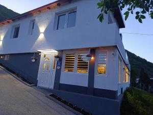 a white house with a door and a window at Apartman Emma in Visoko