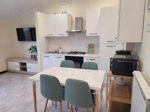 a kitchen with white cabinets and a table and chairs at Bella Todi Apartment 2 in Todi +13 photos