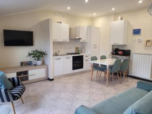 a kitchen with white cabinets and a table with chairs at Bella Todi Apartment 2 in Todi