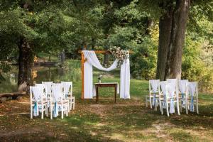 an outdoor ceremony with white chairs and a table at Baťův kanál Babice1 glamping in Babice