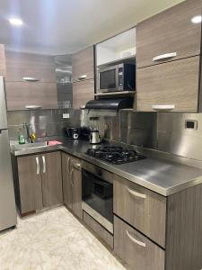 a kitchen with a stove and a microwave at fabuloso primer piso en envigado in Envigado