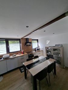 eine Küche mit Tisch und Stühlen in einem Zimmer in der Unterkunft Chalet douceur in Virton + 10 Fotos