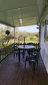 a patio with tables and chairs on a deck at Lodge das Taipas in Santo Amaro