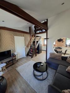 ein Wohnzimmer mit Sofa und Treppe in der Unterkunft Chalet douceur in Virton