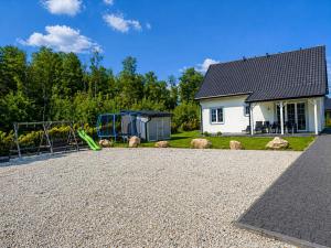 a house with a playground in front of a house at Domek Relaks pod Śnieżką in Miłków