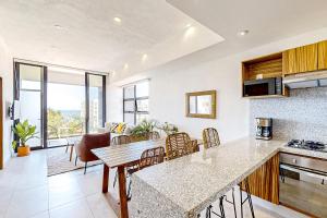 a kitchen and living room with a table and chairs at Ocean-view condo with infinity pool, rooftop lounge, & private balcony in Bucerías