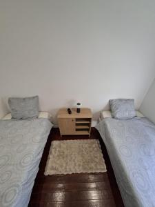 zwei Betten in einem Zimmer mit einem Tisch dazwischen in der Unterkunft Chalet douceur in Virton